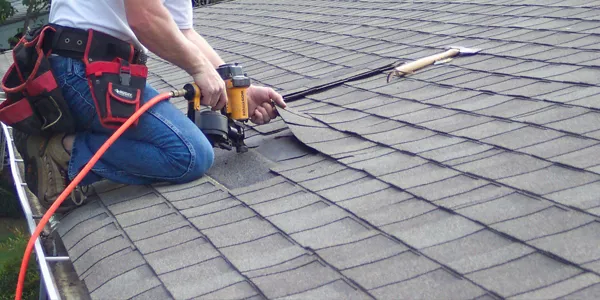 Technicians performing emergency roof repair on Ashwaubenon, WI home after severe windstorm