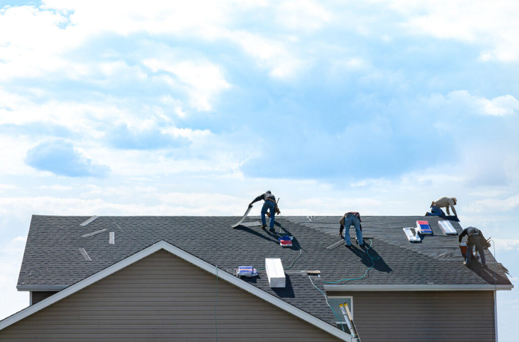 Technicians repairing storm-damaged roof on suburban Brookfield home, ensuring family safety and property value