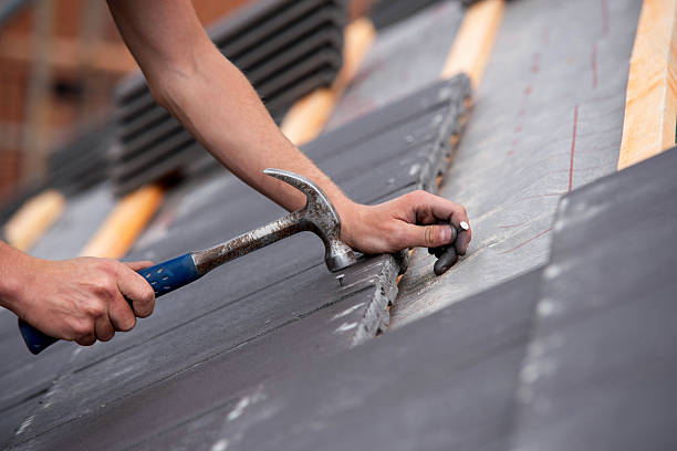 Roof repair technician in Middleton, WI inspecting worn shingles and checking flashing along a dormer